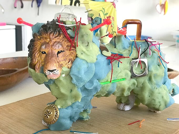 Lion figurine decorated with play dough and other items
