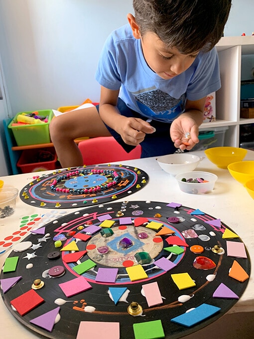 Boy adding art materials to record for mandalas art project