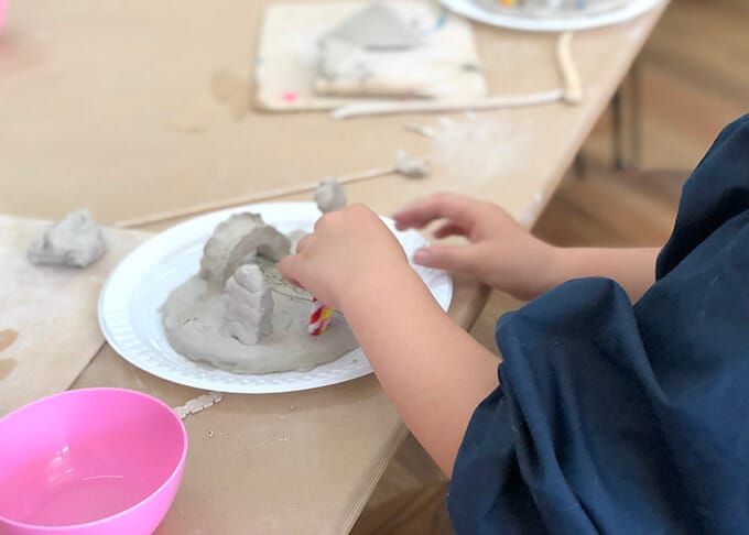 Child shaping clay for small world