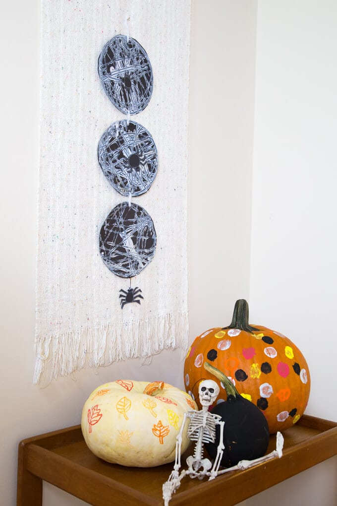 halloween craft ideas – decorated and painted pumpkins with marble painted spiderweb hanging on wall