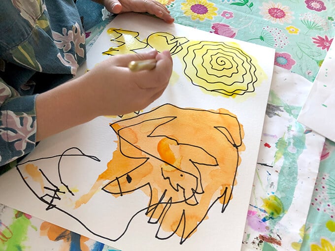 Child drawing on a watercolor painting