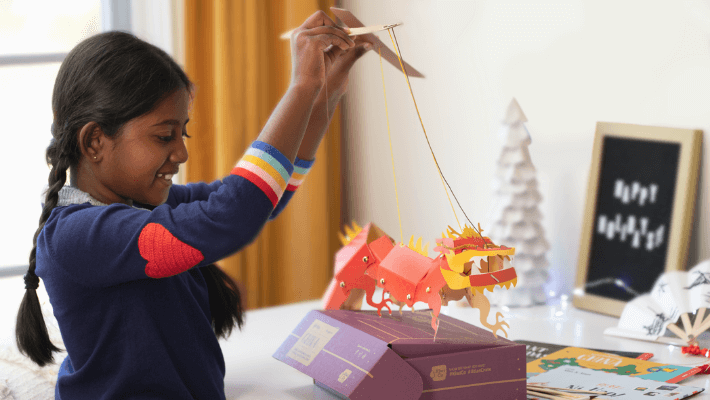 KiwiCo Activity Kits for Kids - girl with a paper dragon marionette