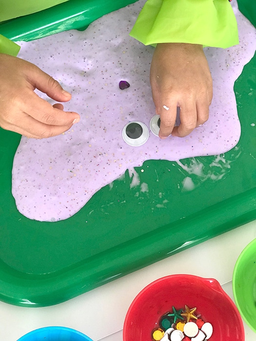Child creating a slime creation with googly eyes