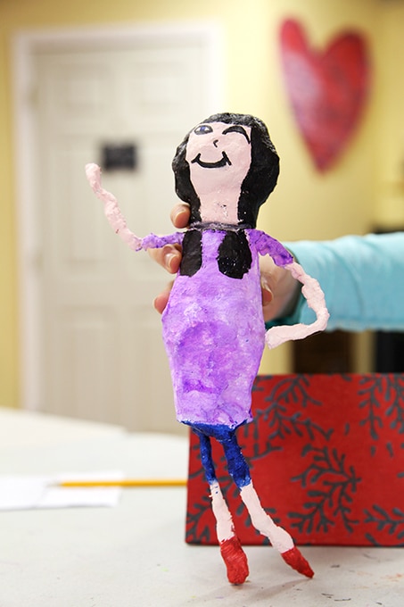 Rigid wrap sculpture of girl wearing purple shirt and blue shorts