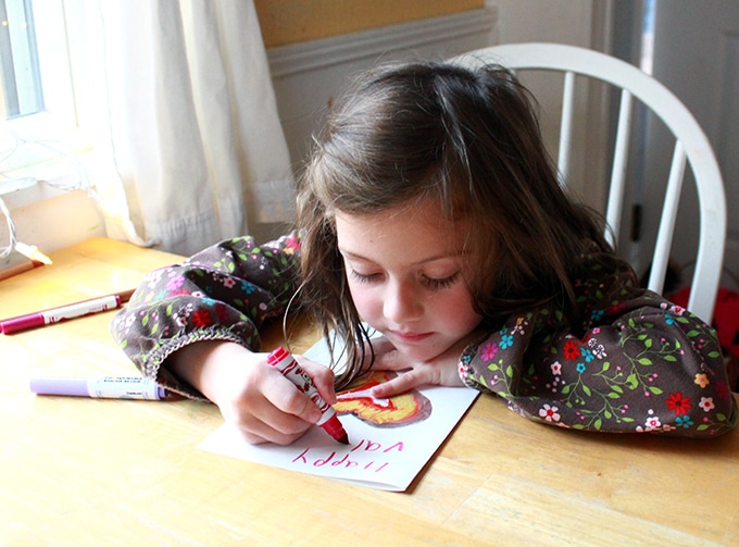 Girl making a foil heart valentines card for Valentine's Day