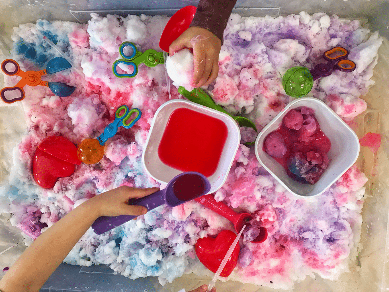 Valentine themed sensory bin with snow, scoopers & liquid watercolors