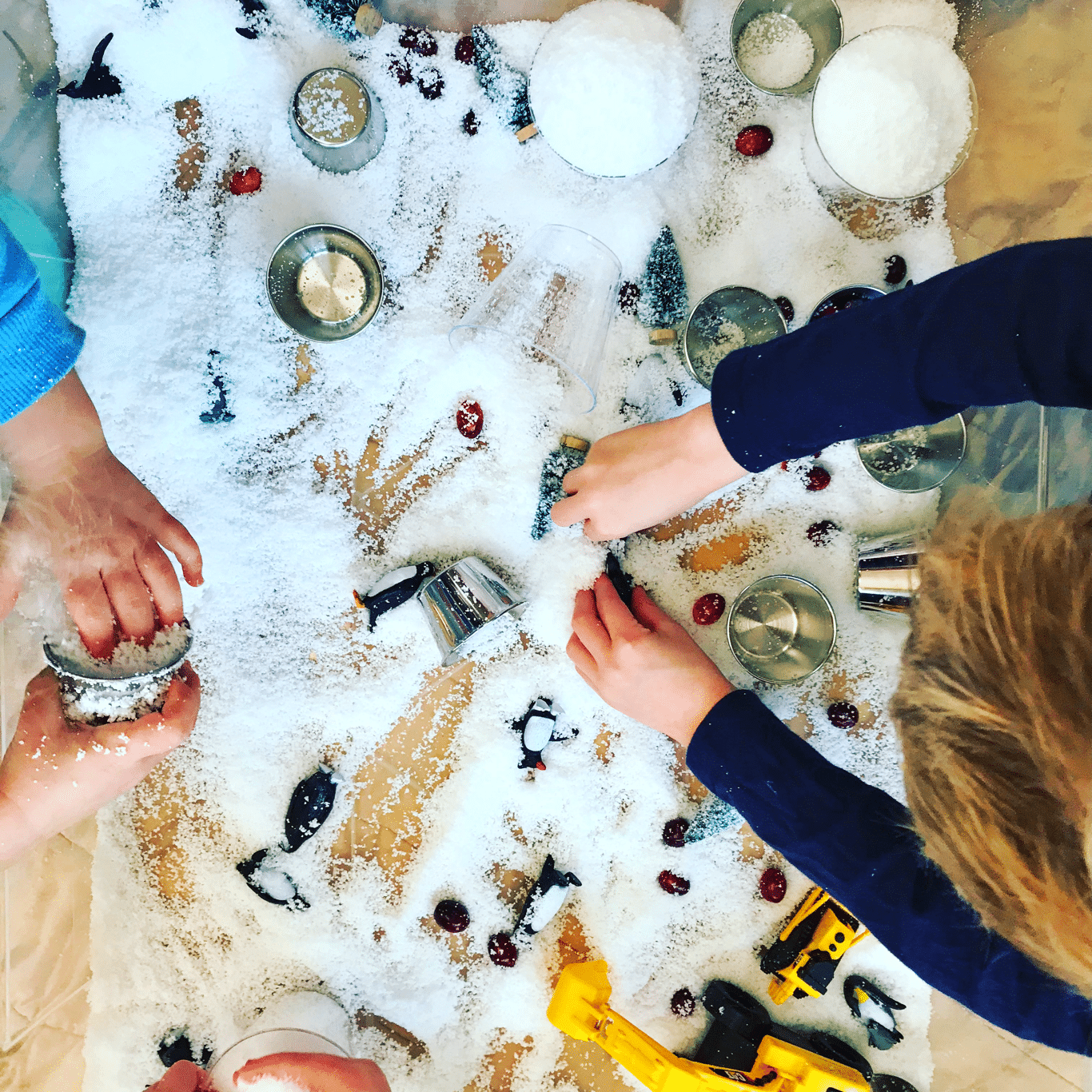 Winter themed sensory bin with snow, diggers & construction vehicles