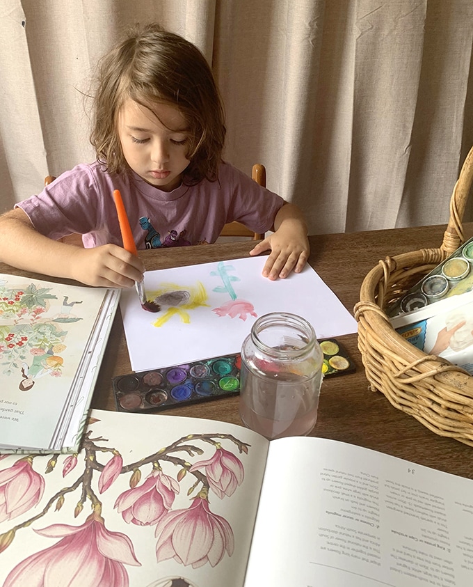 Child painting flowers and surrounded by botanical themed books_Wild Wattle Folk