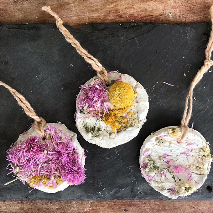 Dried flowers pressed into air dry clay for wall hangings.