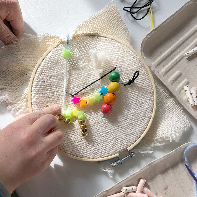 Child stitching burlap & beading