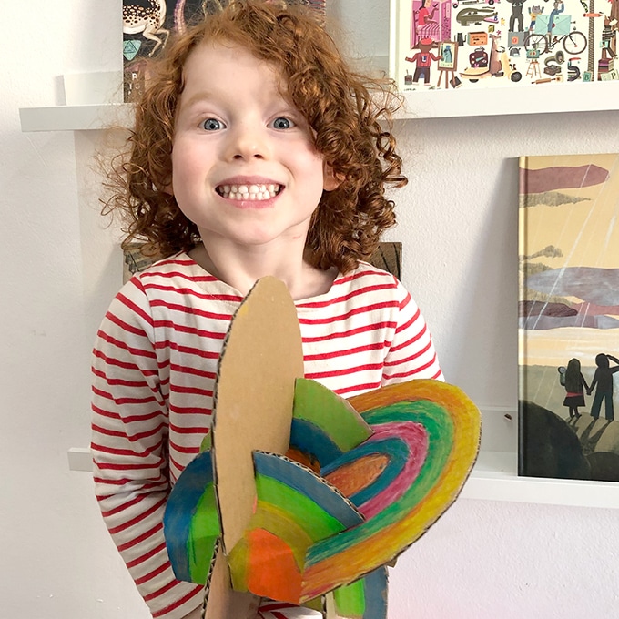 Child-holding-rainbow-cardboard-sculpture