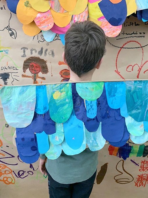 Boy wearing blue paper wings