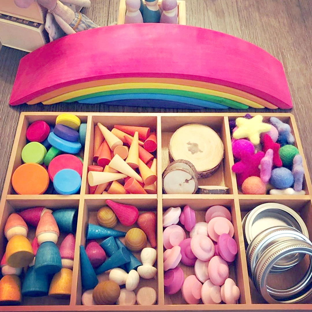 Wooden loose parts play tray with wooden rainbow for creative learning activities for kids. 