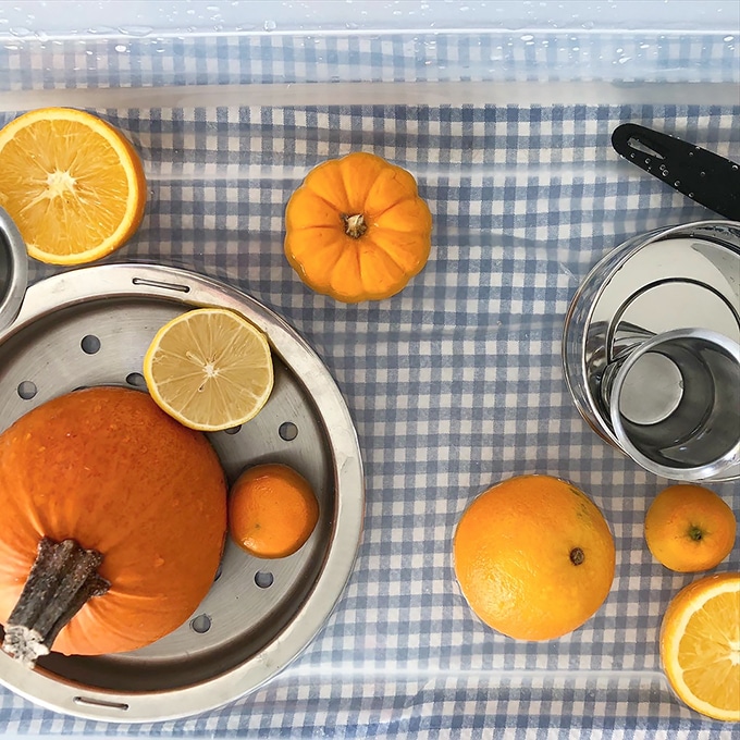 Pumpkin and citrus water play – fall sensory play activities for kids.