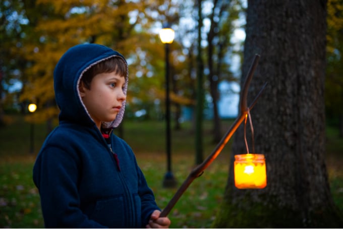 Child holding a glass lantern on a stick