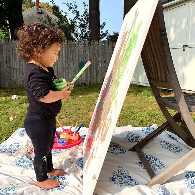 Toddler painting on large canvas