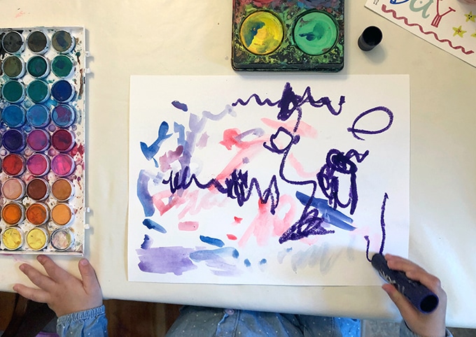 Toddler painting on paper with watercolors and tempera paint sticks. 
