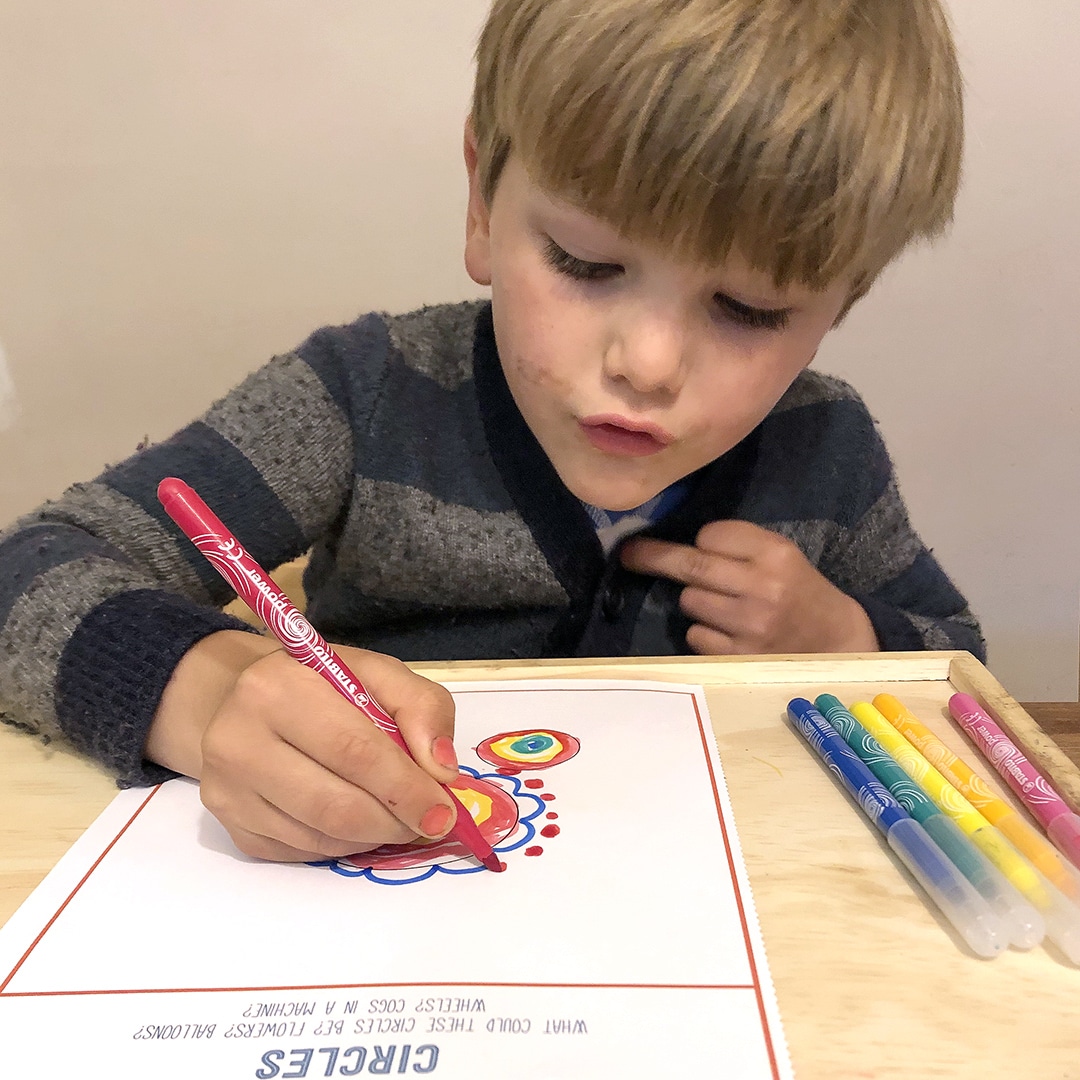 Child using markers with drawing prompt