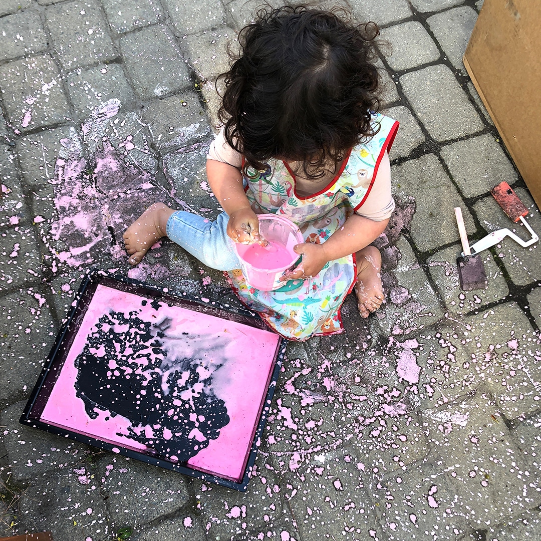 Child painting with sidewalk paint