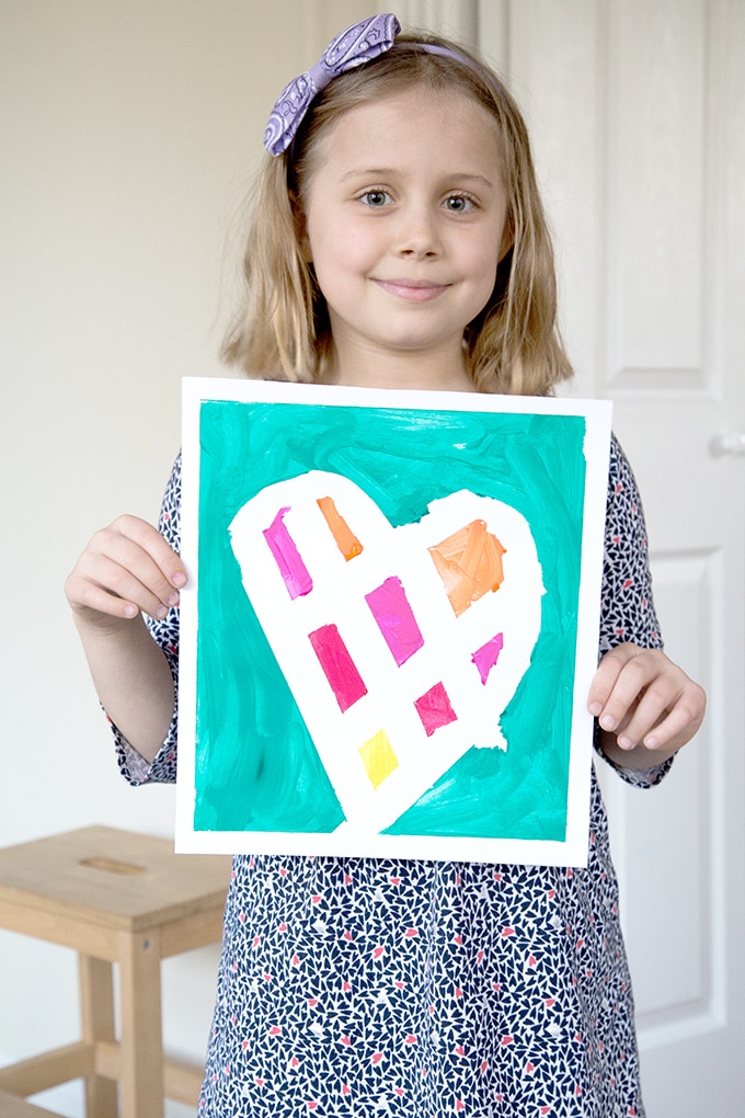 Child holding washi tape painting