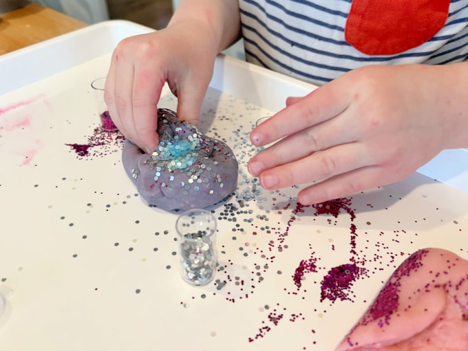 mixing glitter into playdough