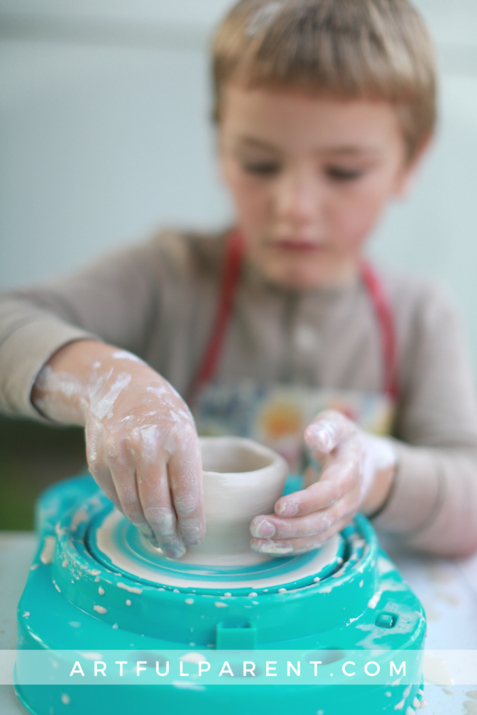 Child raising pot on kids pottery wheel_pin