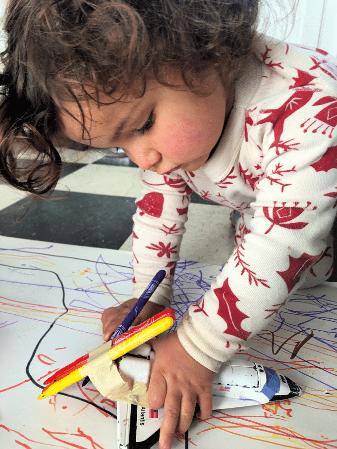 Ella playing with spaceship and markers