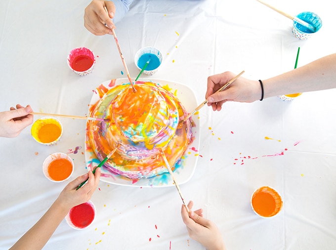 Kids painting white cake