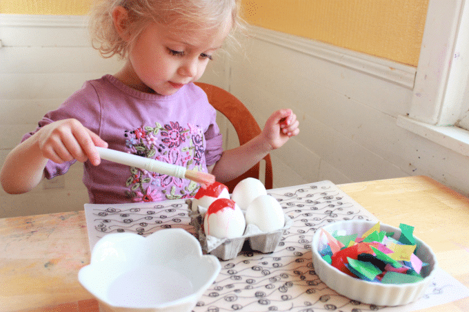 little girl dyeing eggs with tissue paper