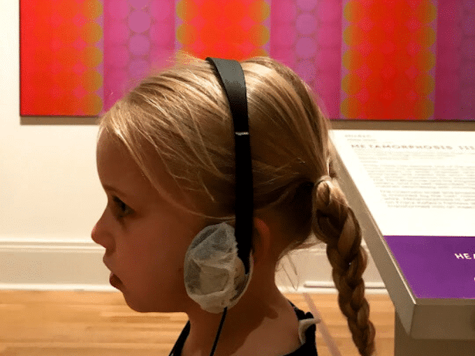 child listening to headphones at museum