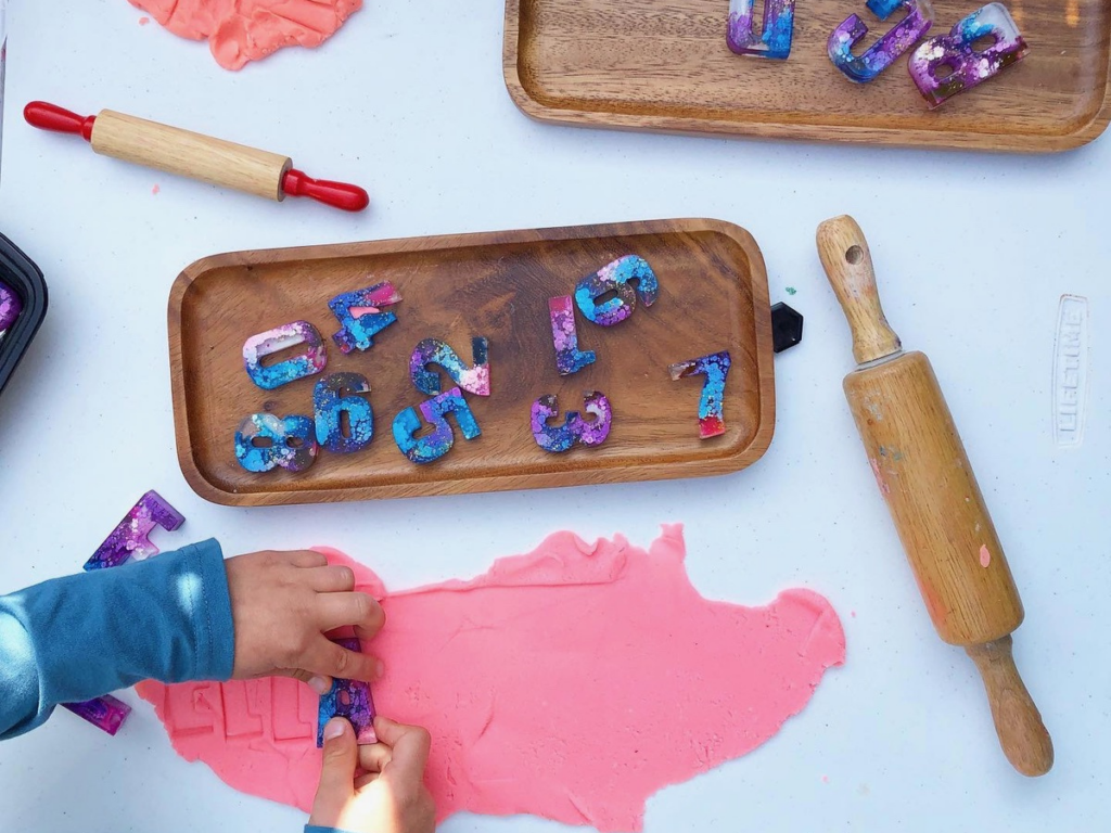 stamping letters into playdough