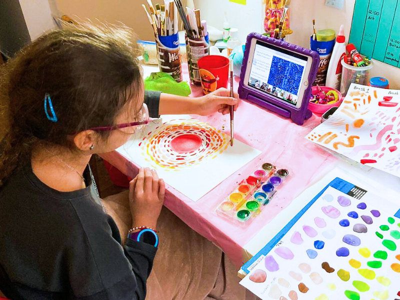 child doing art with video