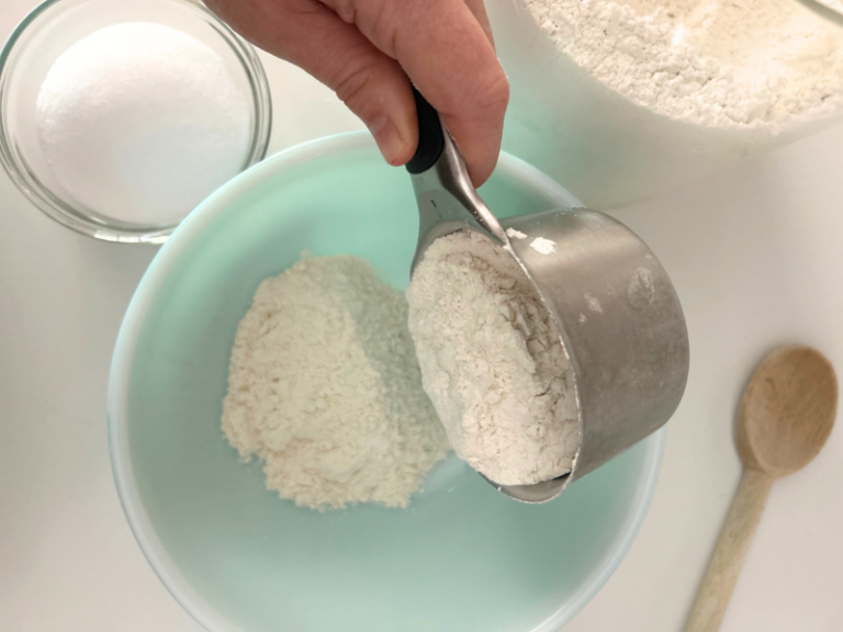 adding flour to bowl