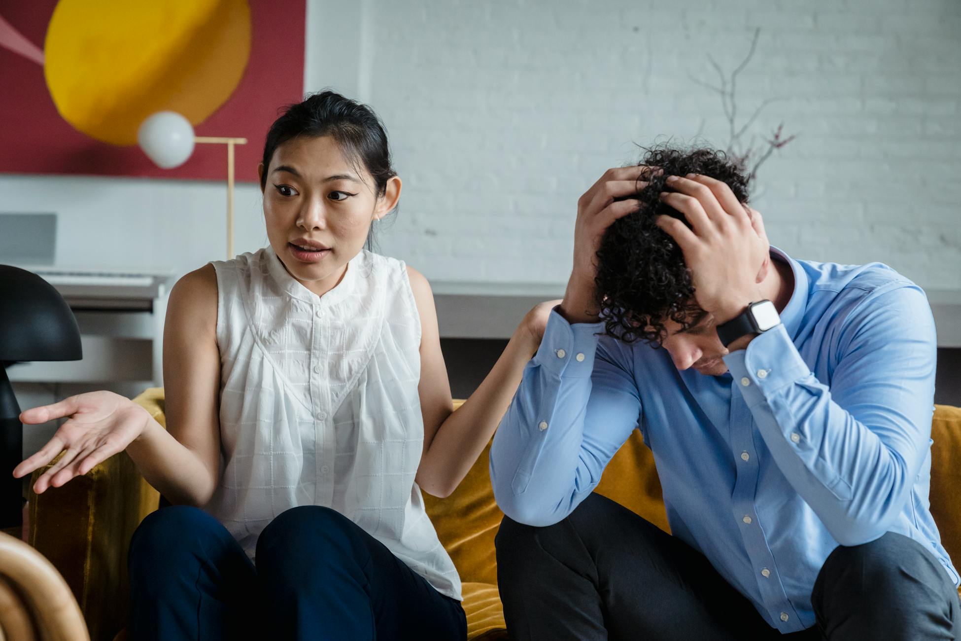A couple having a serious conversation indoors, expressing emotions and misunderstanding.