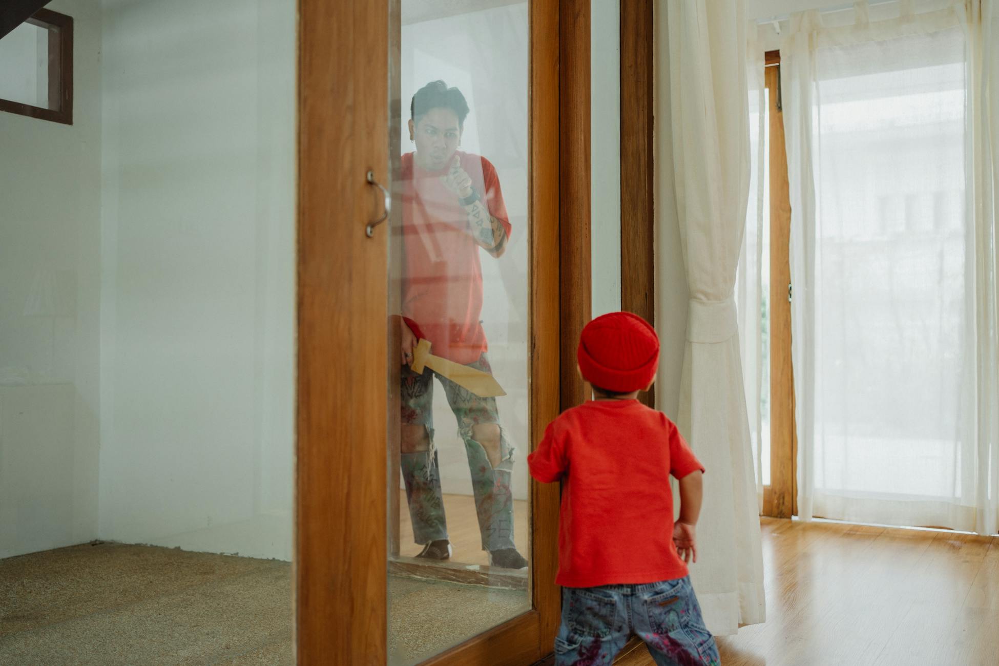A child and father share a playful moment indoors, reflecting joy and bonding.