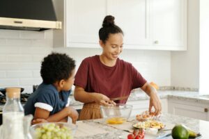 A mother and son enjoy cooking and bonding in a bright modern kitchen.