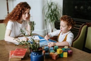 Woman and child spending quality time drawing and painting at home.