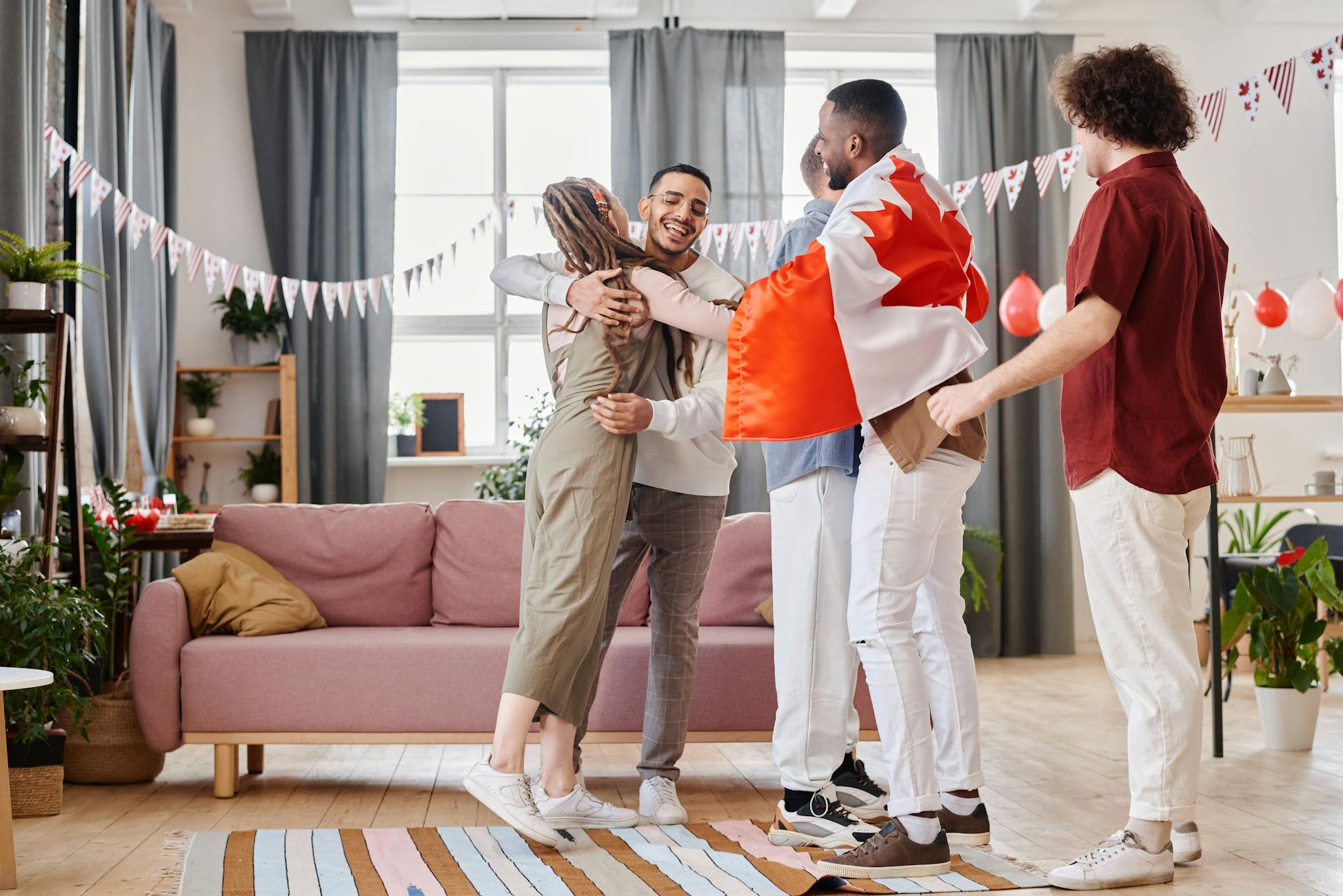 A joyful indoor celebration with diverse friends hugging and enjoying a festive atmosphere.