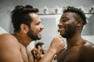 Happy couple sharing a playful morning routine in a bathroom setting.
