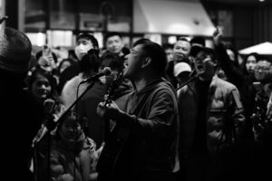 Energetic street musician performing live, surrounded by a captivated crowd.