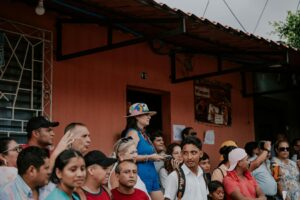 A lively crowd gathers outside a building on a busy city street. Diverse group enjoying a community event.