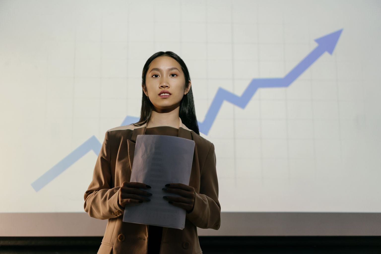 A confident businesswoman presenting a growth chart in a professional setting