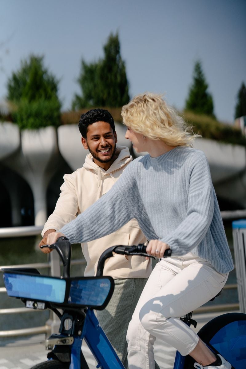 Happy couple riding bicycles together in a park, representative image