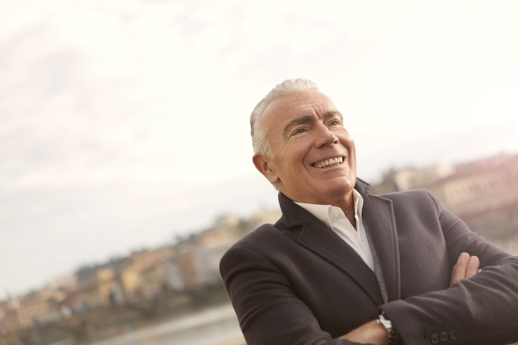 An older adult smiling warmly outdoors