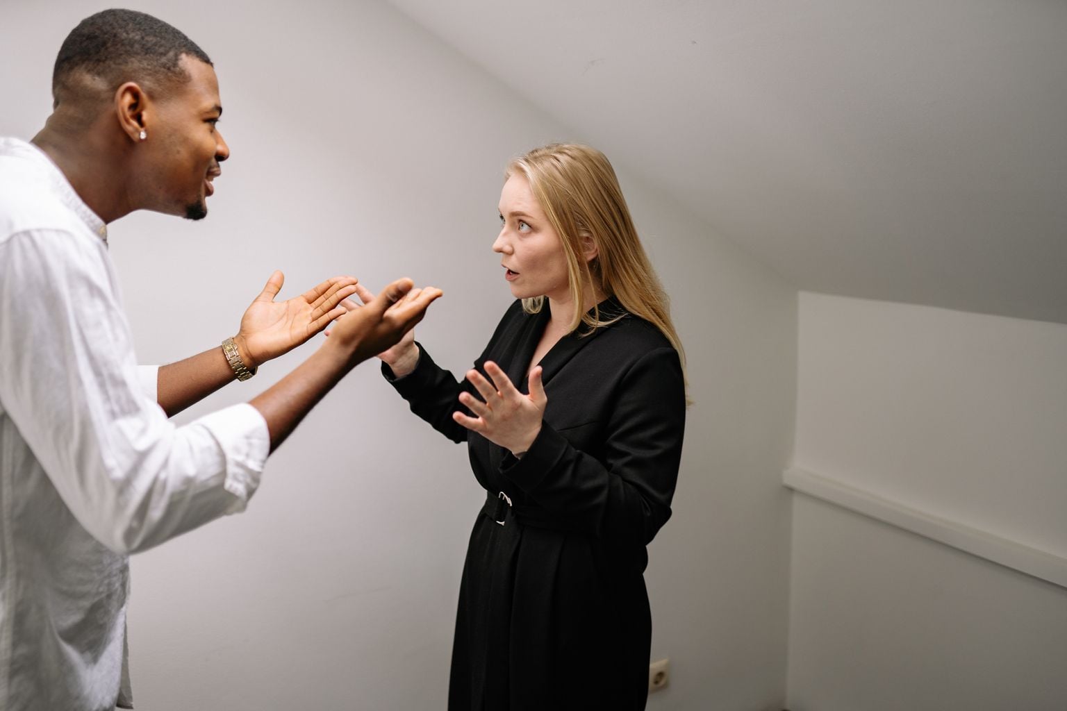 A man and woman having a heated discussion in a minimalistic indoor space