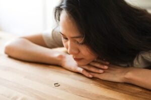 Woman gazing at a wedding ring, contemplating relationship decisions