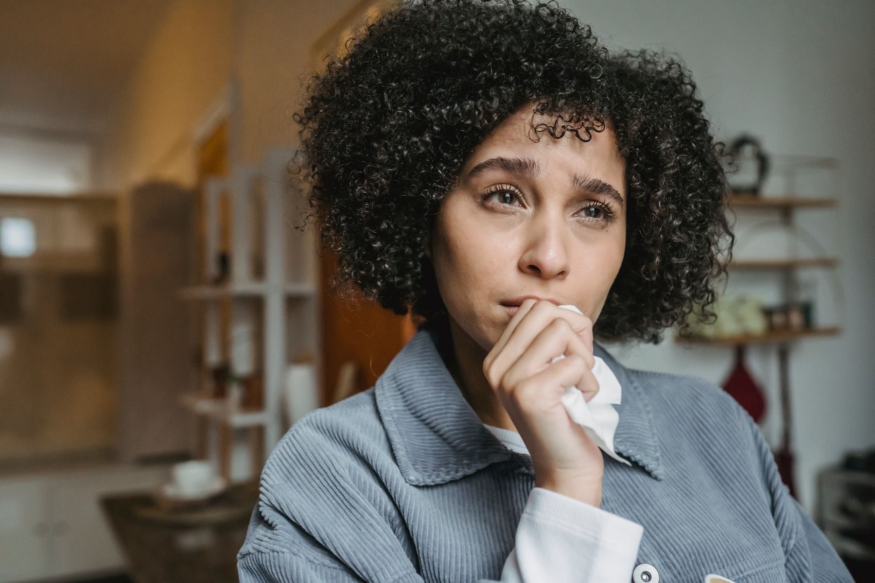 A person sitting with a worried, deep-in-thought expression
